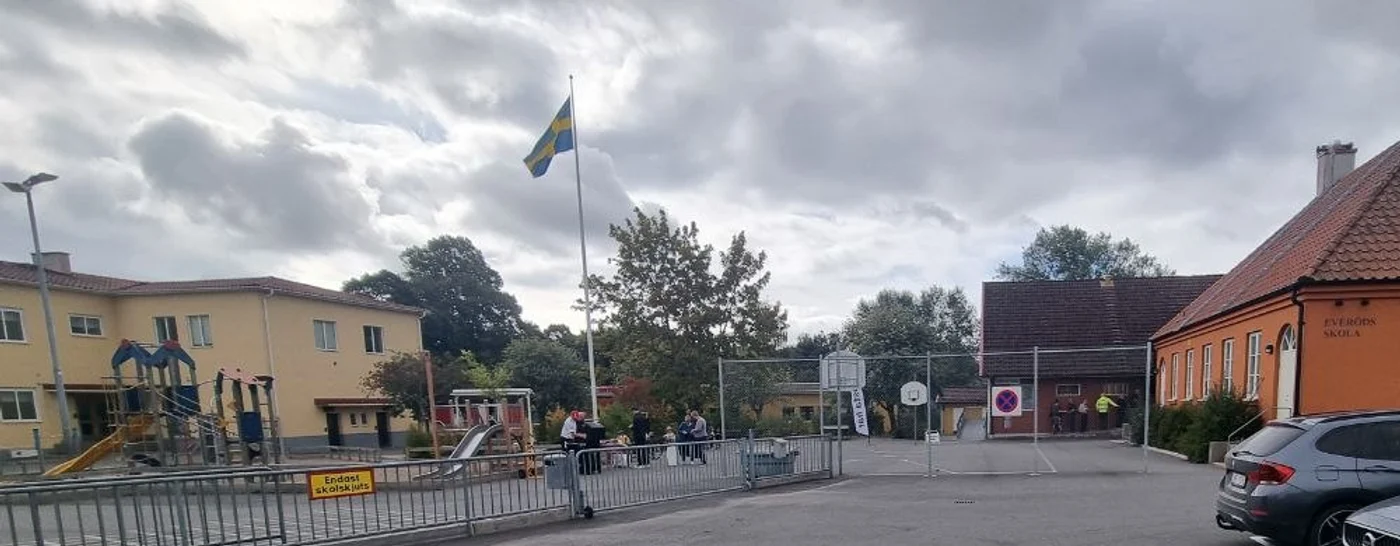 Svensk flagga och människor utanför Everöds skola på valdagen.